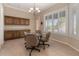 Bright dining area with ample natural light, shuttered windows, built-in cabinetry, and a modern chandelier at 21774 E Camacho Rd, Queen Creek, AZ 85142