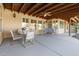 Covered patio featuring a dining table, swing, ceiling fan, and wood beam ceiling, perfect for outdoor entertaining at 21774 E Camacho Rd, Queen Creek, AZ 85142