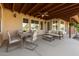 Spacious covered patio with comfortable seating, a dining area, and outdoor ceiling fan at 21774 E Camacho Rd, Queen Creek, AZ 85142