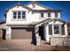 Charming two-story home featuring a stucco facade, stone accents, and a neutral-colored garage door at 5408 W Las Palmaritas Dr, Glendale, AZ 85302