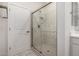 Tiled shower with glass door, and white vanity in a bright bathroom at 5649 N 205Th Ln, Buckeye, AZ 85396