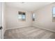 Light-filled bedroom with neutral carpet and multiple windows at 5649 N 205Th Ln, Buckeye, AZ 85396