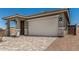 Charming single-Gathering home featuring a front door, two-car garage, and a well-maintained, professionally-designed paver driveway at 5649 N 205Th Ln, Buckeye, AZ 85396