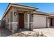 Charming single-Gathering home featuring a front door, two-car garage, and a well-maintained, professionally-designed paver driveway at 5649 N 205Th Ln, Buckeye, AZ 85396