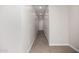 A brightly-lit hallway with white walls, white trim, wood-look ceramic tile flooring, and doors leading to other rooms at 5649 N 205Th Ln, Buckeye, AZ 85396
