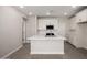 Open kitchen featuring a large island, white cabinetry, stainless steel appliances and tile backsplash at 5649 N 205Th Ln, Buckeye, AZ 85396