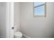 Powder room with a modern white toilet and natural light from the window at 5649 N 205Th Ln, Buckeye, AZ 85396