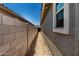 Side yard space with concrete block wall and clear, blue skies above the home's side exterior at 5649 N 205Th Ln, Buckeye, AZ 85396