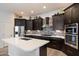 Beautiful kitchen featuring dark cabinets, stainless steel appliances, and stylish backsplash at 7979 E Princess Dr # 13, Scottsdale, AZ 85255