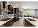 Open kitchen layout with island, stainless appliances, dark cabinets, and access to the dining area at 7979 E Princess Dr # 13, Scottsdale, AZ 85255