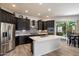Modern kitchen with stainless steel appliances, dark wood cabinets, and a center island at 7979 E Princess Dr # 13, Scottsdale, AZ 85255