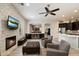 Inviting living room with stone fireplace, modern fan, and seamless access to the kitchen at 7979 E Princess Dr # 13, Scottsdale, AZ 85255