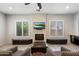 Cozy living room featuring a stone fireplace, plantation shutters, and comfortable seating at 7979 E Princess Dr # 13, Scottsdale, AZ 85255