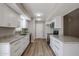 Modern kitchen features white cabinets, granite countertops, stainless steel appliances, and wood-look flooring at 9346 E Citrus N Ln, Sun Lakes, AZ 85248