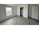 Bright bedroom with wood-look floors, large closet, and window at 12601 S Hermit Rd, Buckeye, AZ 85326