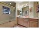 Well-lit bathroom with a tiled shower, wood cabinets, and a decorative rug at 6411 S River Dr # 26, Tempe, AZ 85283