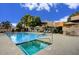 Community pool with hot tub surrounded by lounge chairs and umbrellas at 6411 S River Dr # 26, Tempe, AZ 85283