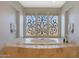 Spa-like bathroom featuring a luxurious soaking tub and large windows at 6486 E Oberlin Way, Scottsdale, AZ 85266