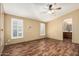 Spacious bedroom with wood-look flooring, ceiling fan, and large windows with shutters at 16246 N 32Nd Way, Phoenix, AZ 85032