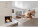 Cozy living room featuring a fireplace and mid-century furniture at 2343 E Orangewood Ave, Phoenix, AZ 85020