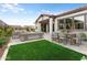 Inviting backyard features an expansive patio with seating and dining areas, and a manicured lawn at 4779 N 205Th Gln, Buckeye, AZ 85396