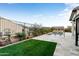 The backyard features a pool, artificial grass, lush plants, and travertine tile at 4779 N 205Th Gln, Buckeye, AZ 85396