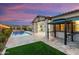 Beautiful backyard at twilight featuring a sparkling pool and outdoor grill area at 4779 N 205Th Gln, Buckeye, AZ 85396