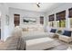 Stylishly staged bedroom with modern decor, large windows, and seating area; perfect for relaxation at 4779 N 205Th Gln, Buckeye, AZ 85396