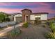 Charming home with desert landscaping, stone accents, and a tiled roof under a vibrant twilight sky at 4779 N 205Th Gln, Buckeye, AZ 85396