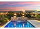 Stunning pool area featuring elegant stone waterfall, landscape lighting and vibrant twilight skies at 4779 N 205Th Gln, Buckeye, AZ 85396