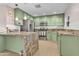 Renovated kitchen with light green cabinets, stainless steel appliances, and granite countertops at 4830 E Palm Ln, Phoenix, AZ 85008