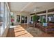 Inviting sun room with comfortable leather chairs, wood floors, and sliding glass doors leading to outdoor living at 14401 W Gunsight Dr, Sun City West, AZ 85375