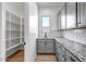 Well-organized pantry with gray cabinets and granite countertop at 20105 W Campbell Ave, Buckeye, AZ 85396