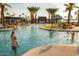 Community pool area with people enjoying the water and recreational amenities on a sunny day at 20105 W Campbell Ave, Buckeye, AZ 85396