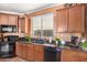 Kitchen with dark granite countertops and copper backsplash at 31101 N 136Th Ln, Peoria, AZ 85383