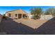 Large gravel backyard featuring desert landscaping and covered patio with sliding glass doors at 36375 W Picasso St, Maricopa, AZ 85138