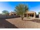 Gravel backyard with desert landscaping featuring block wall and covered patio with sliding glass door at 36375 W Picasso St, Maricopa, AZ 85138