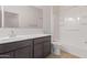 Bathroom featuring a single sink vanity, white walls, and bath/shower combo at 36375 W Picasso St, Maricopa, AZ 85138