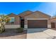 Traditional-style home featuring a two car garage, desert landscaping and neutral toned stucco at 36375 W Picasso St, Maricopa, AZ 85138