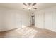 Bright bedroom with ceiling fan and double closets at 5022 E Magic Stone Dr, Phoenix, AZ 85044