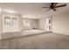 Spacious living room with carpeting, double doors and a ceiling fan at 5022 E Magic Stone Dr, Phoenix, AZ 85044