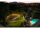 Nighttime aerial view showing backyard oasis with pool, spa, and string lights at 6501 E Cholla St, Scottsdale, AZ 85254