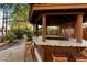 Outdoor bar with stone countertop and seating in a landscaped backyard at 6501 E Cholla St, Scottsdale, AZ 85254