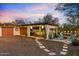 Evening view of a backyard with seating area, fire pit, and string lights at 6501 E Cholla St, Scottsdale, AZ 85254