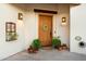 Inviting entryway with a rustic wooden door and potted plants at 6501 E Cholla St, Scottsdale, AZ 85254