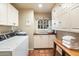 Bright laundry room with white cabinets, washer, dryer and extra storage at 6501 E Cholla St, Scottsdale, AZ 85254