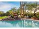 Stunning pool and waterfall surrounded by trees at 6501 E Cholla St, Scottsdale, AZ 85254