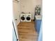 Well-lit laundry room featuring modern washer and dryer, sleek gray cabinets, and a water heater at 6842 W Holly St, Phoenix, AZ 85035