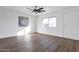 Spacious living room featuring wood-look floors and ceiling fan at 6842 W Holly St, Phoenix, AZ 85035