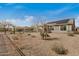 View of backyard showing desert landscaping, block wall fencing, and patio roof at 26783 W Zachary Dr, Buckeye, AZ 85396